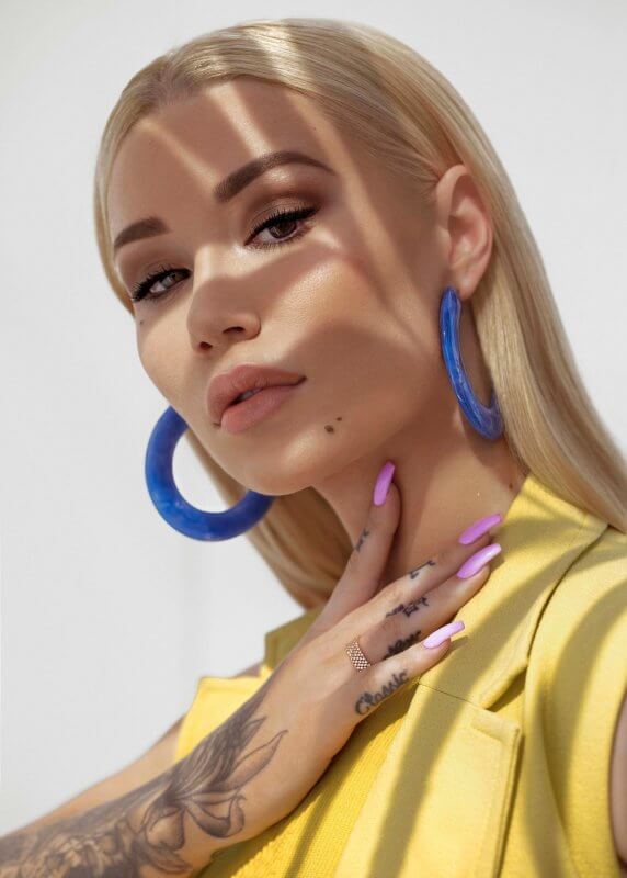 Iggy Azalea in a yellow tailored top and blue hoop earrings photographed by Steven Taylor for GQ